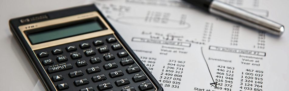 Close-up of financial documents with calculator and pen, ideal for business management themes.