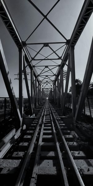 Monochrome photo of a steel bridge over train tracks, Ath Thumayd, Sudan.