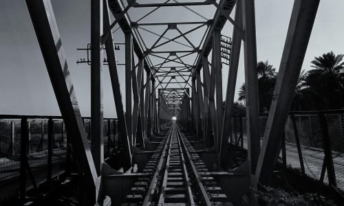Monochrome photo of a steel bridge over train tracks, Ath Thumayd, Sudan.