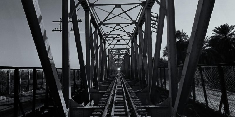 Monochrome photo of a steel bridge over train tracks, Ath Thumayd, Sudan.